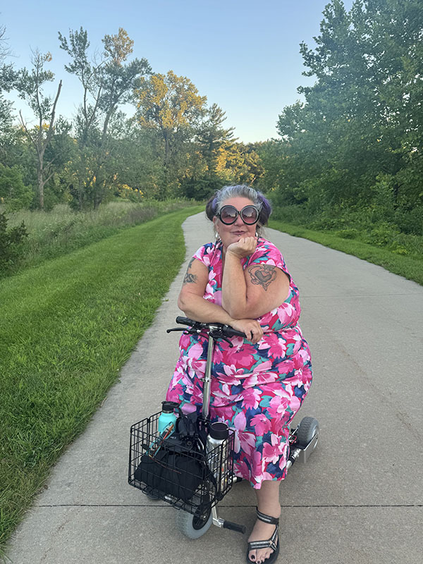 a woman poses on her motorized wheelchair