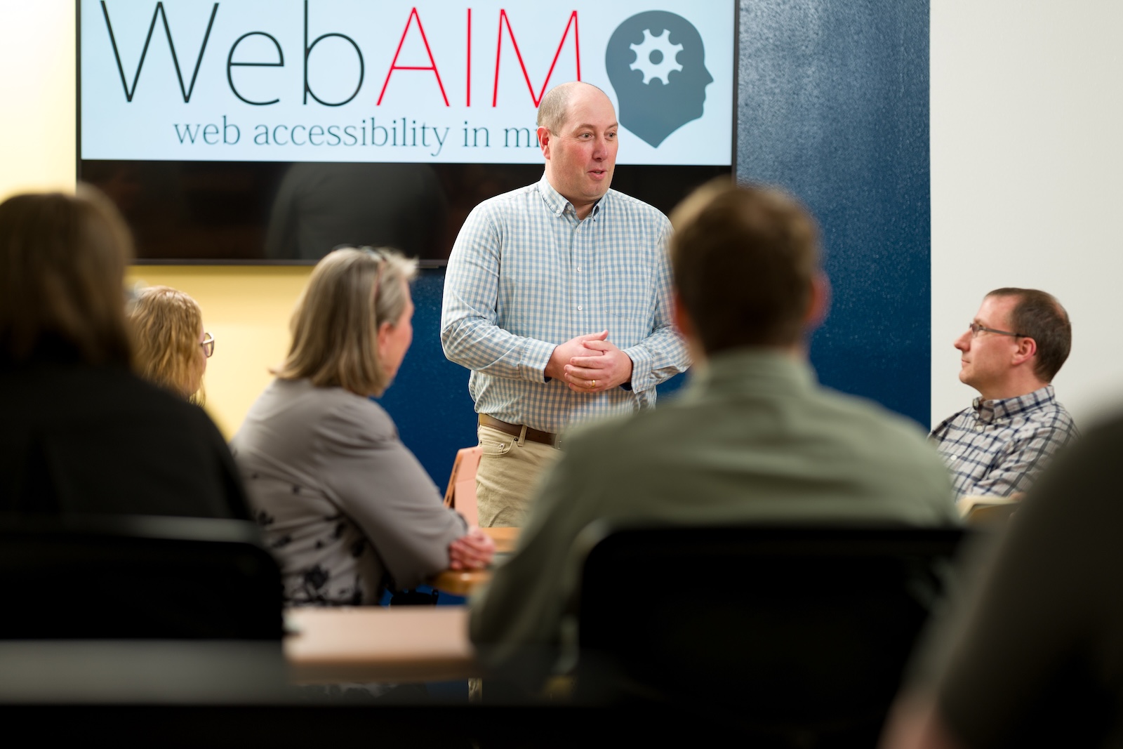 A man instructs a group about web accessibility.