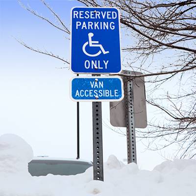 Wheelchair parking sign in a snowbank