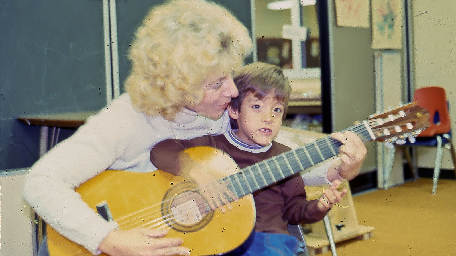 a woman sings with a child in a 70s-era photo