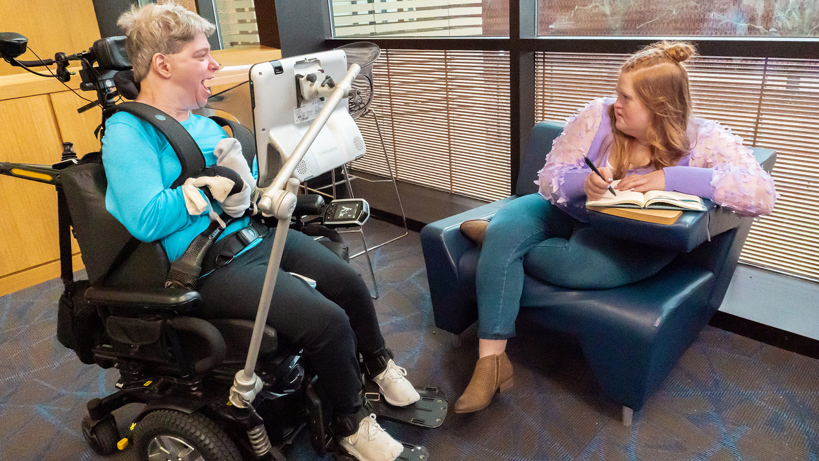 two women with disabilities talk in a university setting