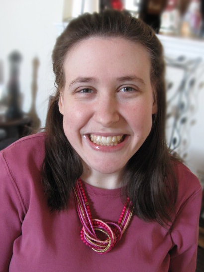 Kirsten Barraclough wearing a pink shirt and necklace. She is smiling.