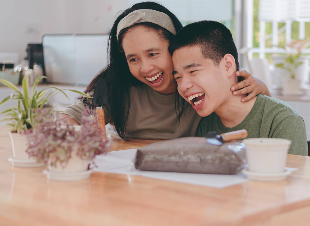 A other and her teenage son with developmental disability laughing together